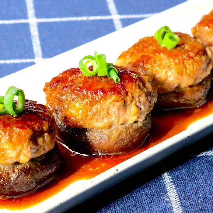 料理の写真です。豚ひき肉を詰めたしいたけが白い皿に並べられています。