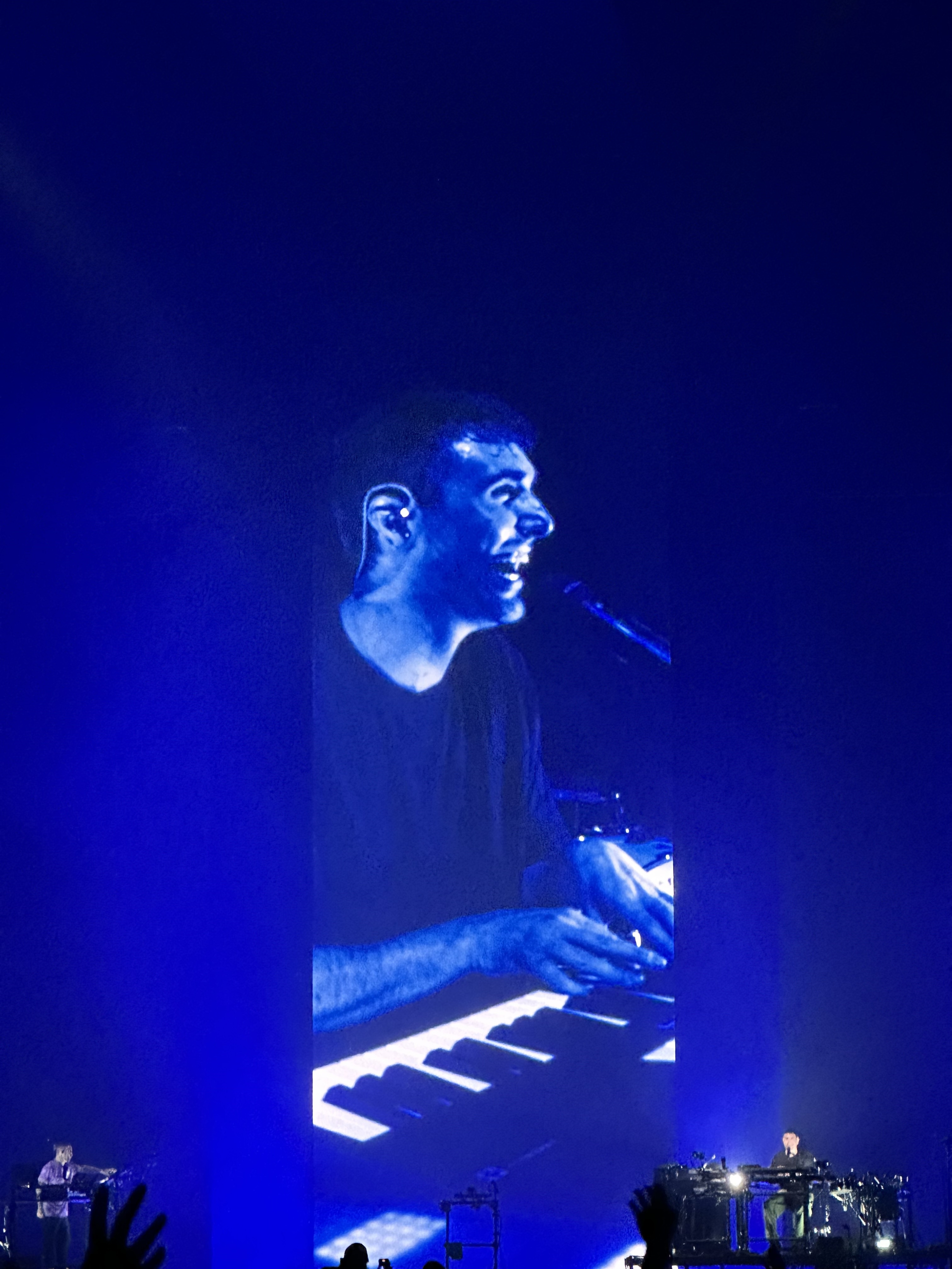 Man performing live on piano projected on large screen