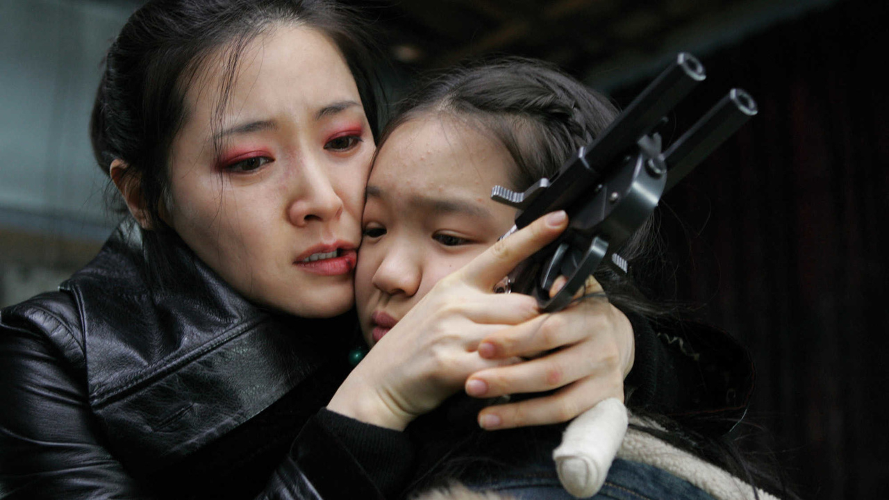 A woman comforts a child while holding a gun, expressing distress and protection