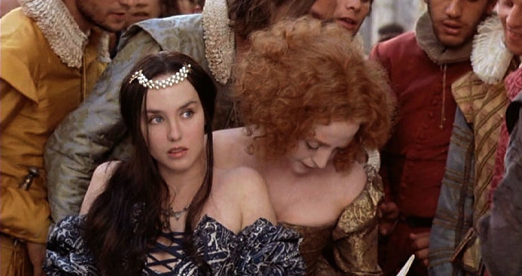 Two women in historical dresses, one with a tiara, in a crowd from the film &#x27;Ever After&#x27;