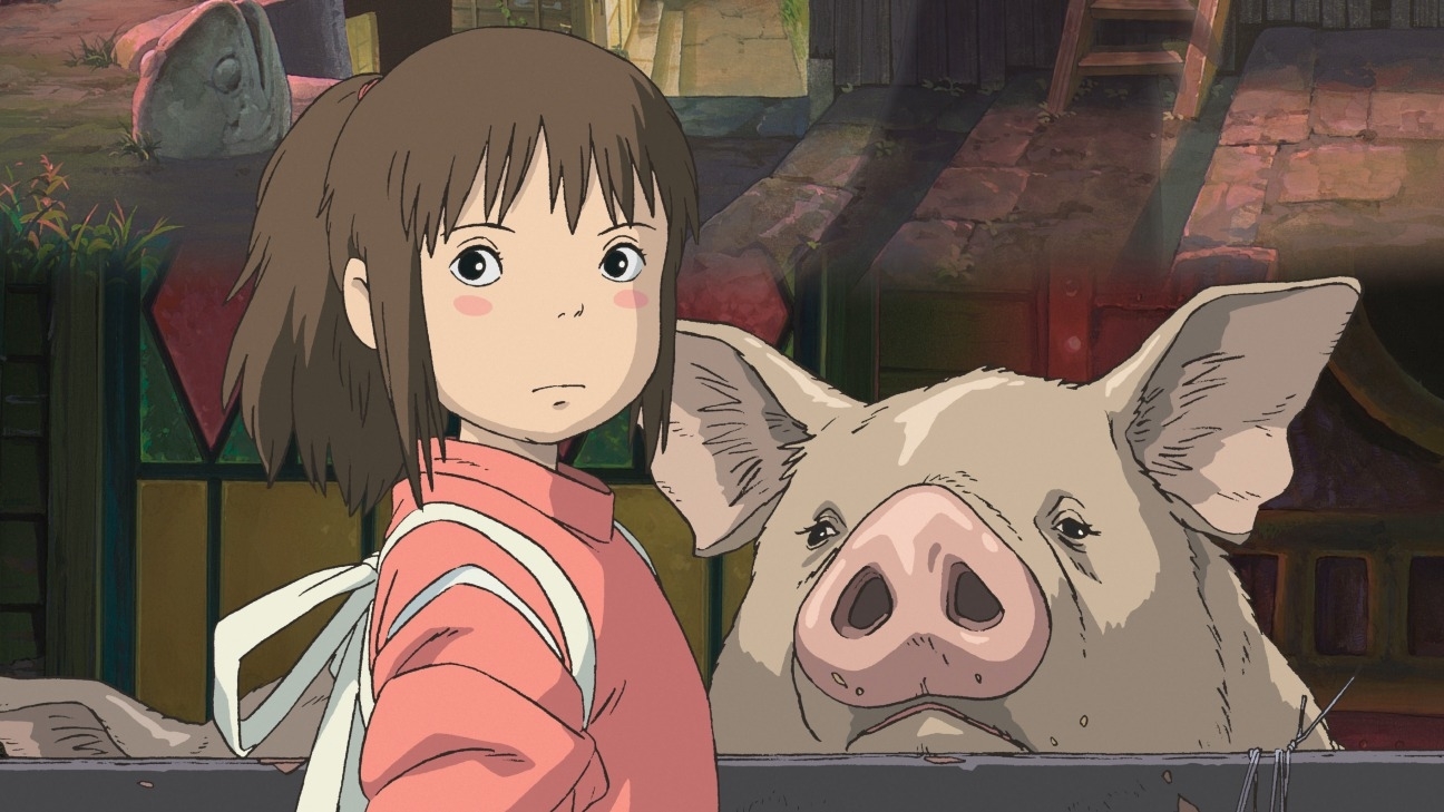 Chihiro with a backpack stands next to a small pig with a city background