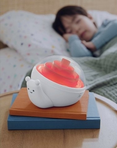 Person resting behind a cute bear-shaped humidifier atop books