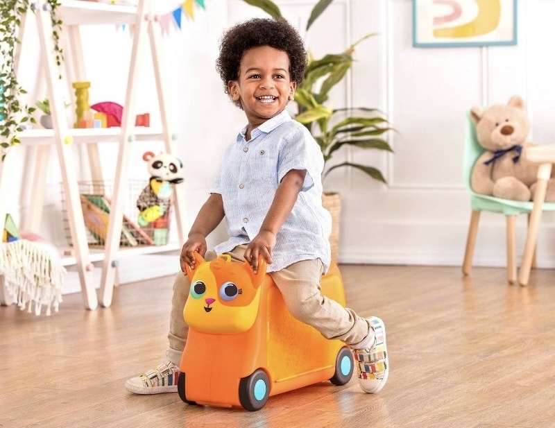 Child riding a toy scooter in a playroom