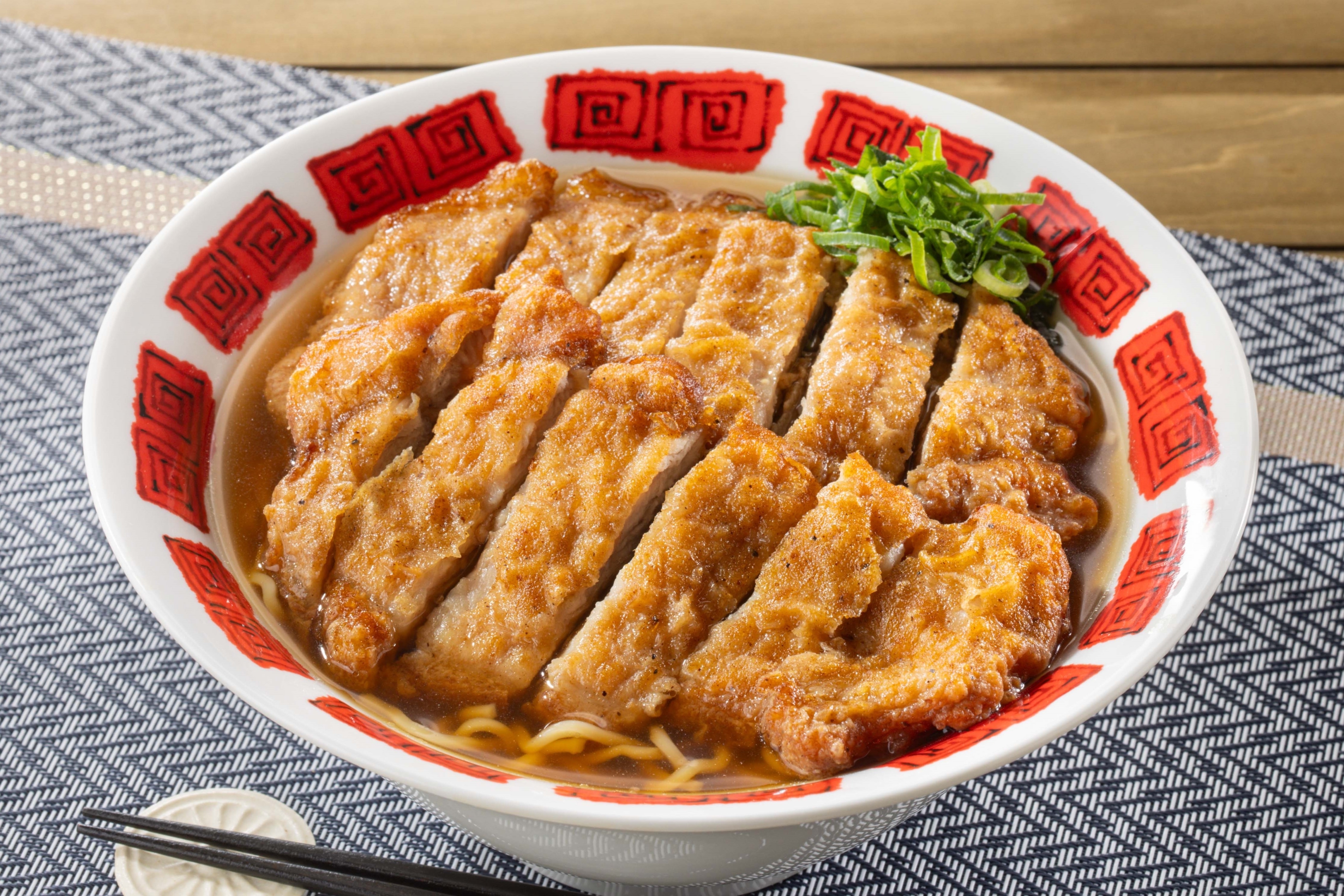 唐揚げがのったラーメンの丼、ネギをトッピング