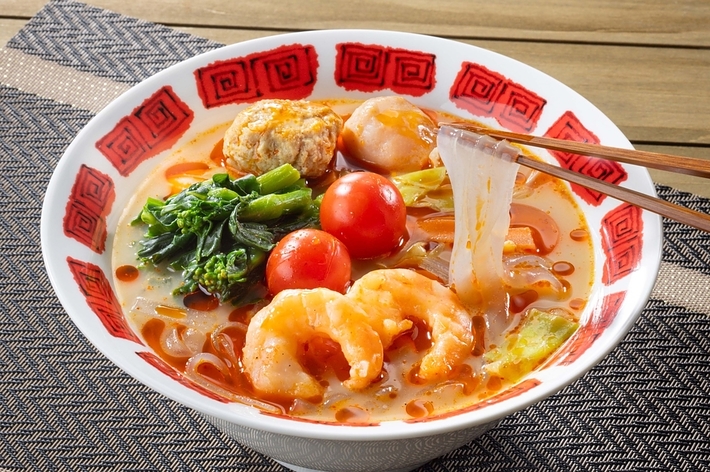 ラーメンにエビや野菜がトッピングされた料理。