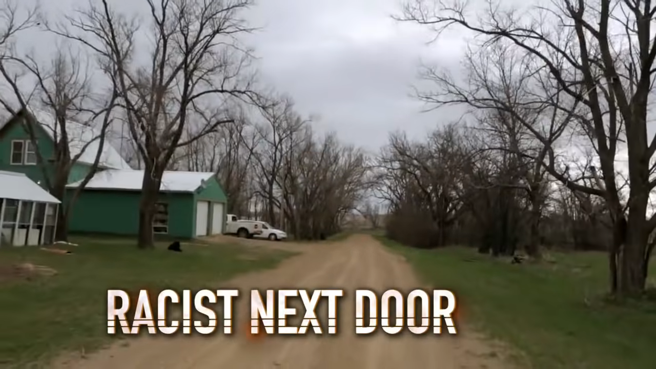 Dirt road leading to a green house with bare trees on the sides, captioned &quot;RACIST NEXT DOOR&quot;