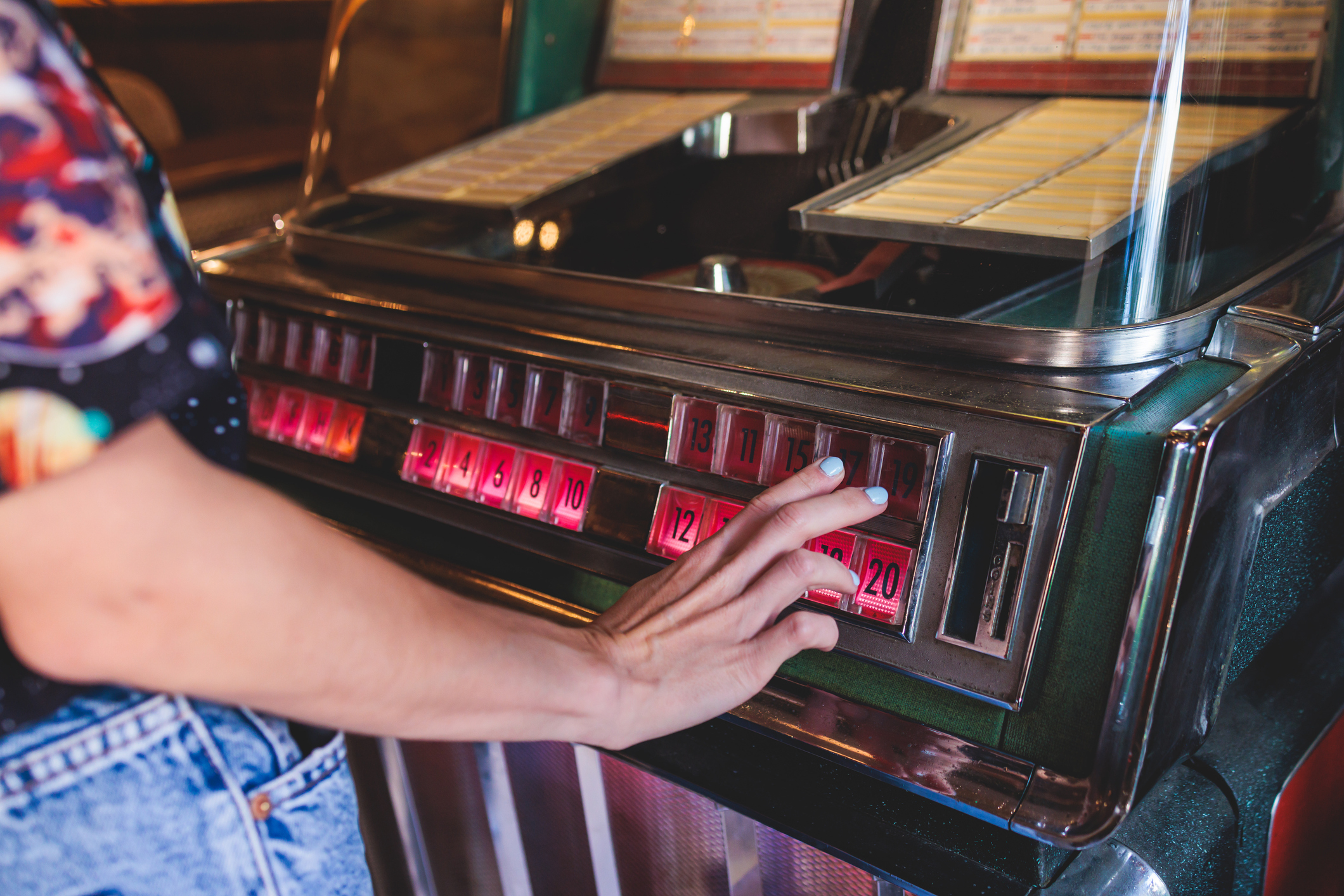 Person selecting a song on a vintage jukebox