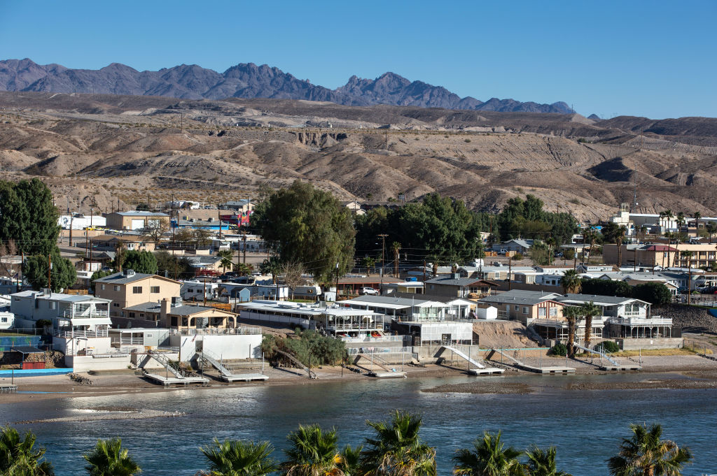 View of a small town with houses along a waterfront, set against a backdrop of distant mountains