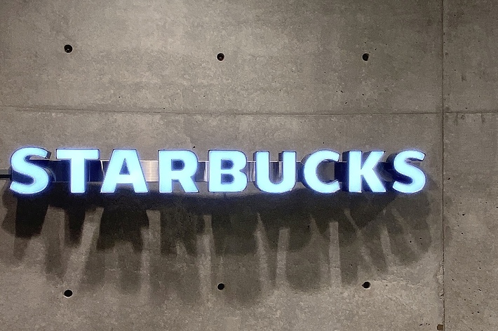 スターバックスのネオンサインが壁に掛かっている写真です。