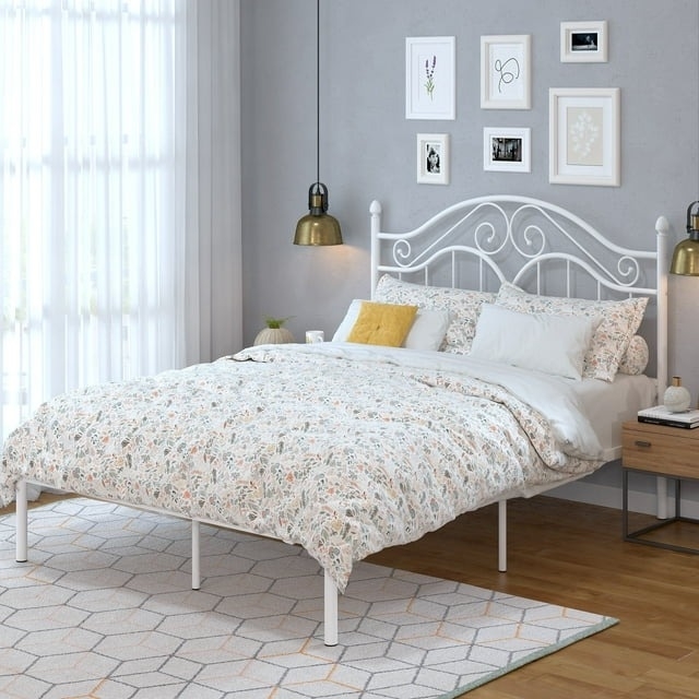 Elegant bedroom with a white wrought iron bed frame, floral bedding, and wall art