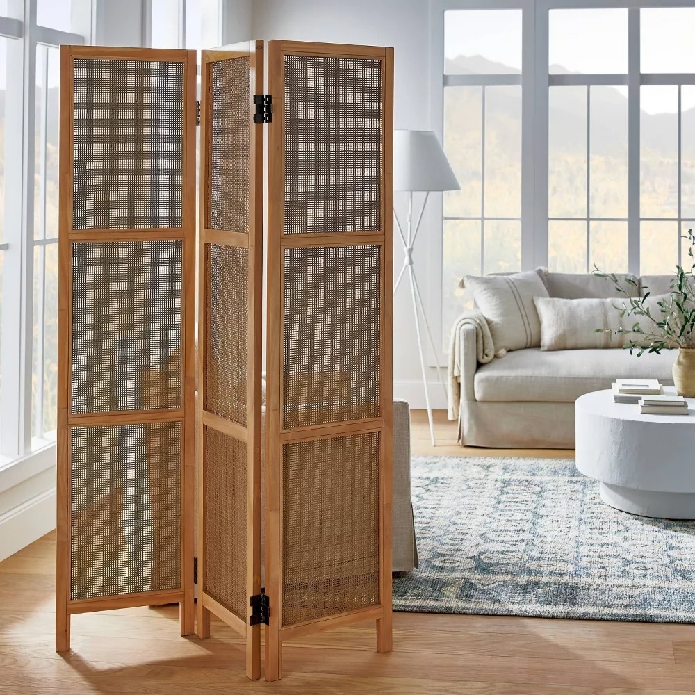 A wooden room divider with three panels, standing in a living room