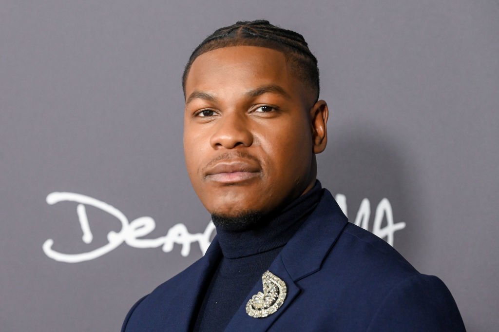 Man in a stylish suit with embellished lapel posing for the camera