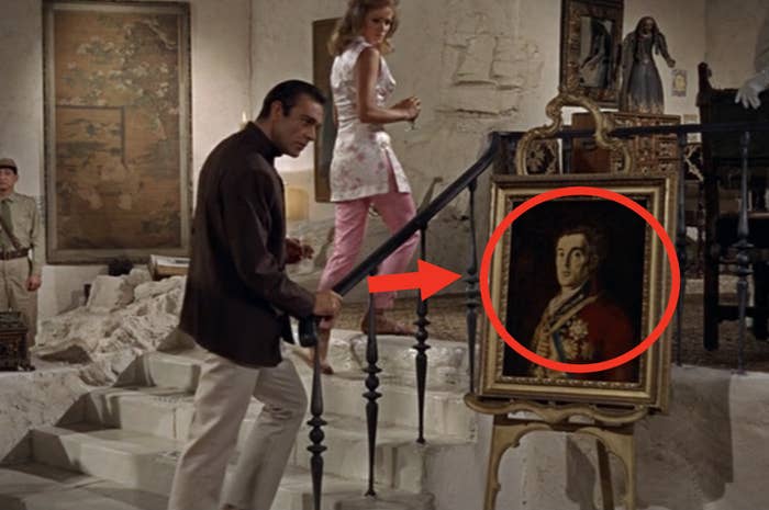 Scene from a film with actors and a portrait of a historical figure on an easel