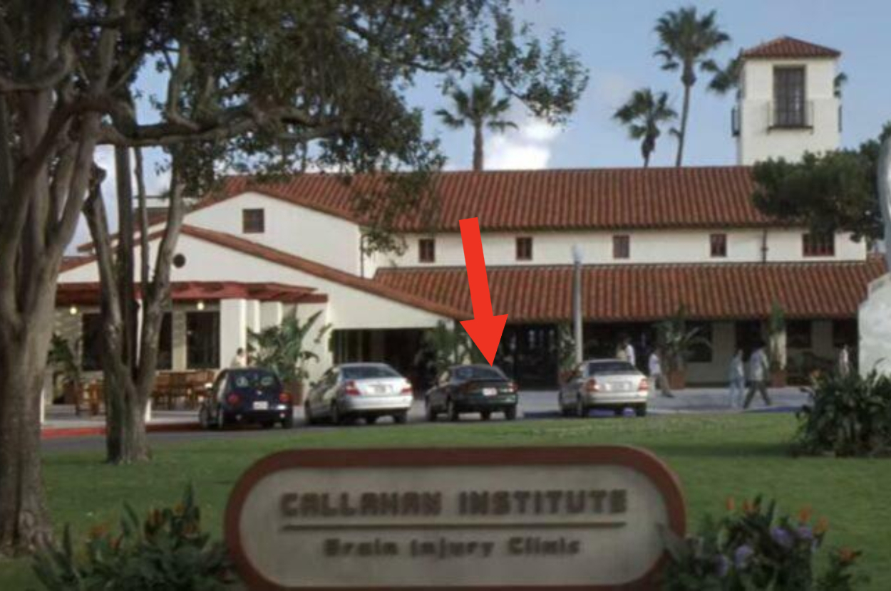 Image from a film showing the exterior of the fictional Callahan Institute with an arrow pointing to a character