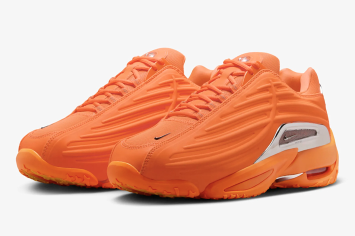 A pair of Nike Air Max Tailwind IV sneakers in orange with the Nike Swoosh logo visible