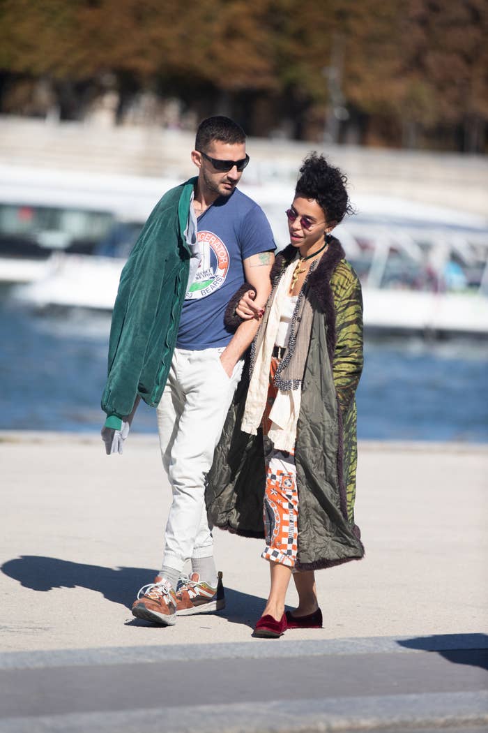 The Two  walking, one in a green jacket and the other in a patterned scarf and coat
