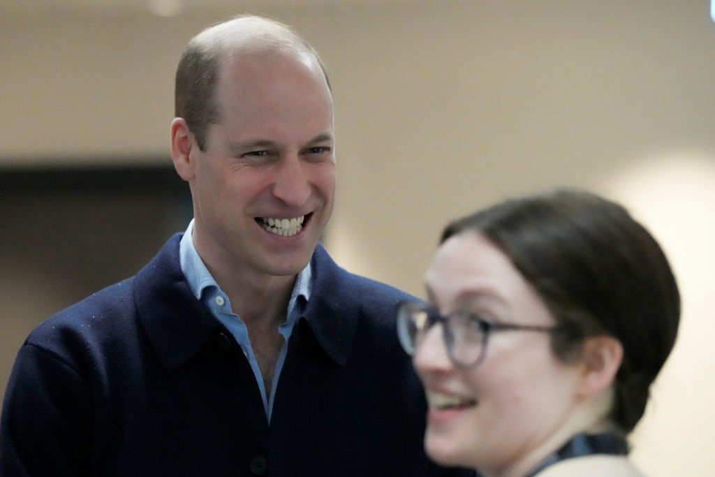 Prince William smiling in conversation with a woman