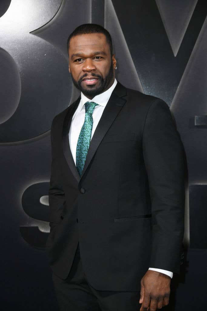 Curtis &quot;50 Cent&quot; Jackson poses in a black suit with a green tie at an event