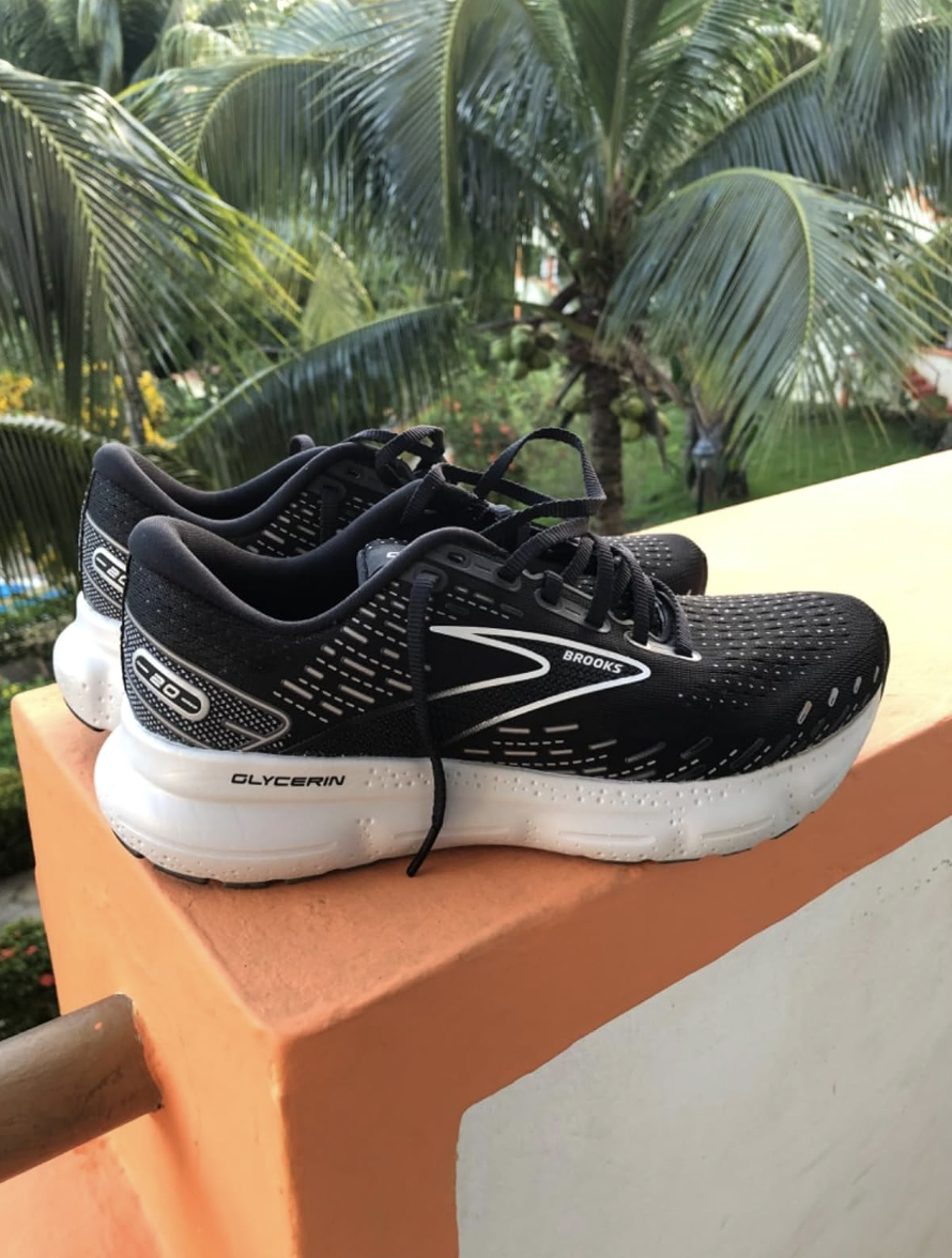 Pair of Brooks Glycerin running shoes on a ledge with palm trees in the background