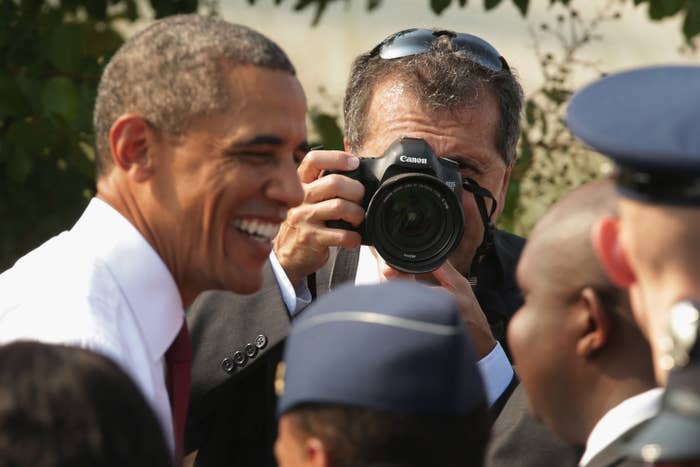 Obama smiling near a camera held by Pete and surrounded by people