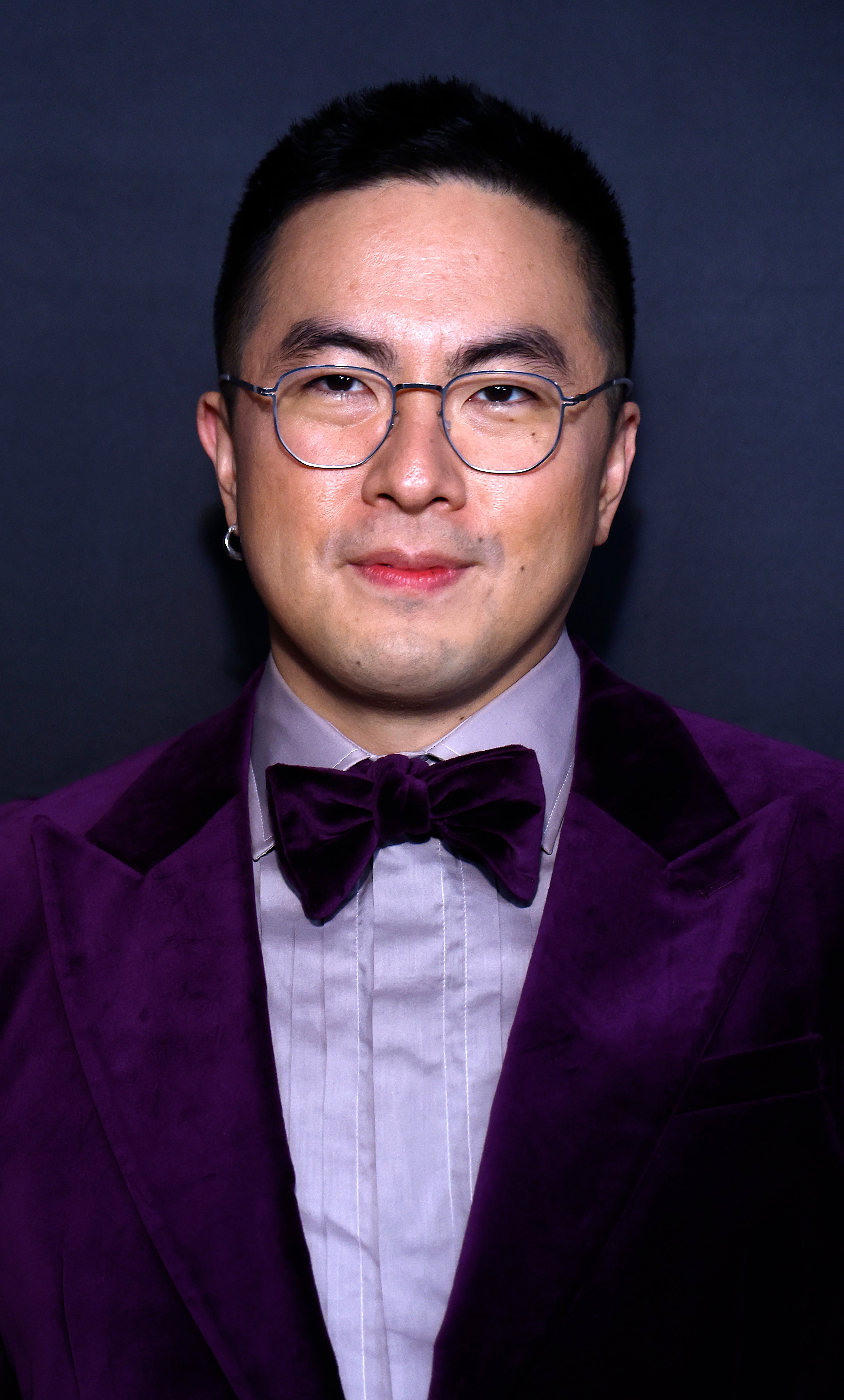Bowen Yang posing in a velvet tuxedo with a bow tie