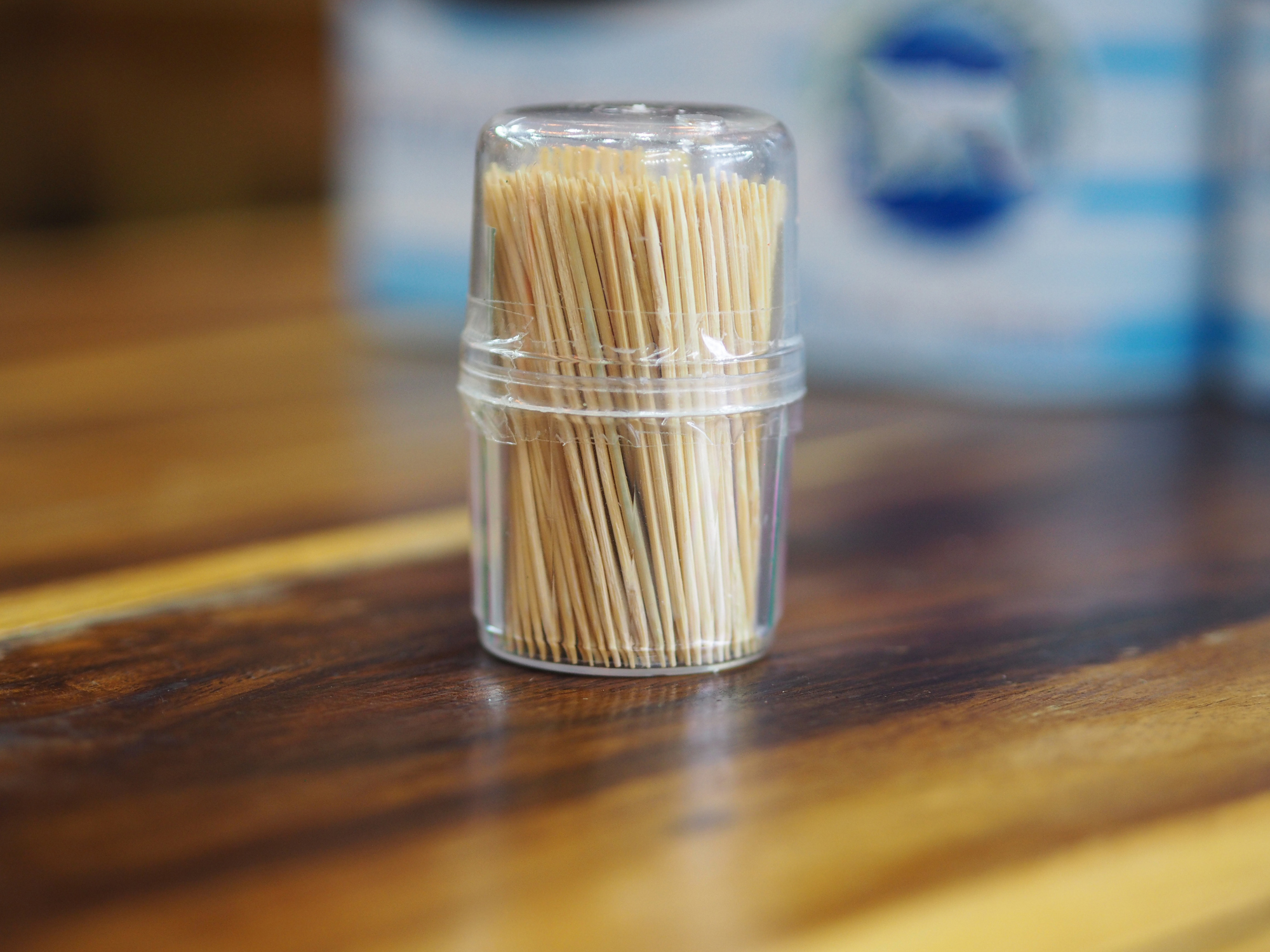 Container of toothpicks on a wooden table