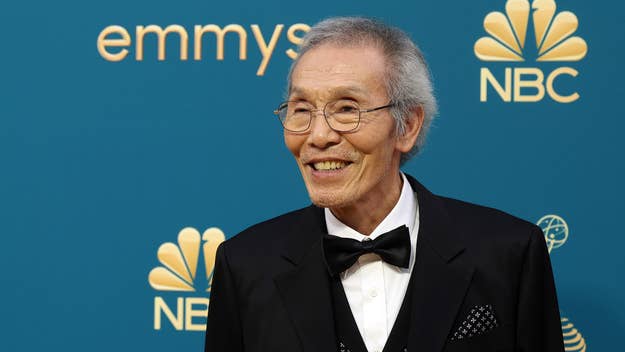 Elderly man in a black tuxedo smiling on the Emmy Awards red carpet