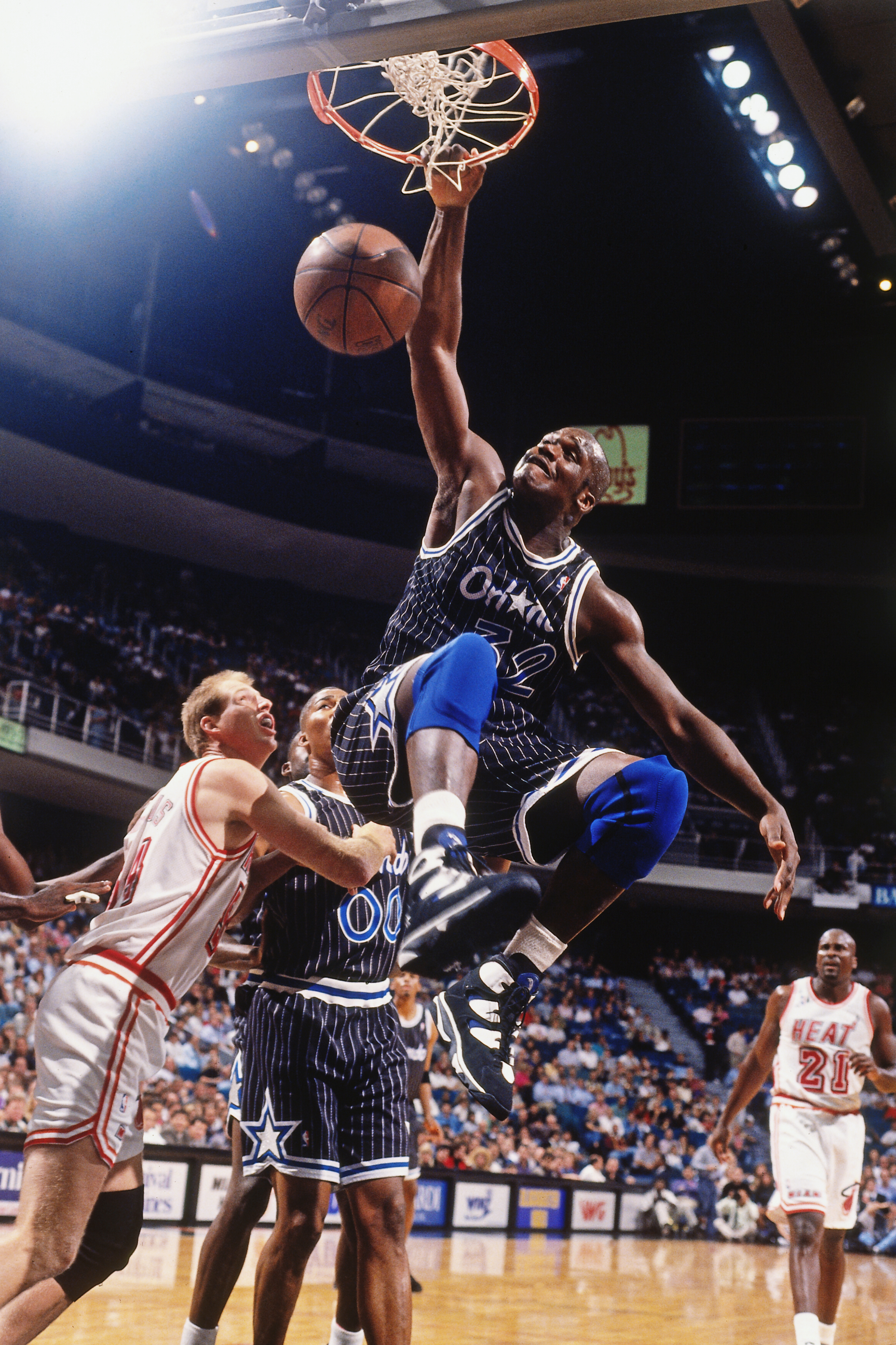 Orlando Magic player in mid dunk over a Chicago Bulls defender during a basketball game