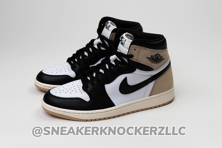 A pair of high-top sneakers with contrasting panels and a swoosh logo