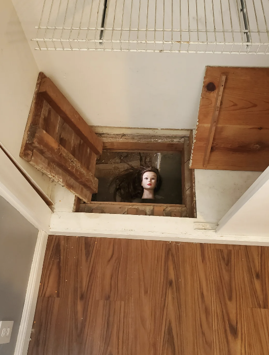 a mannequin head in a crawlspace