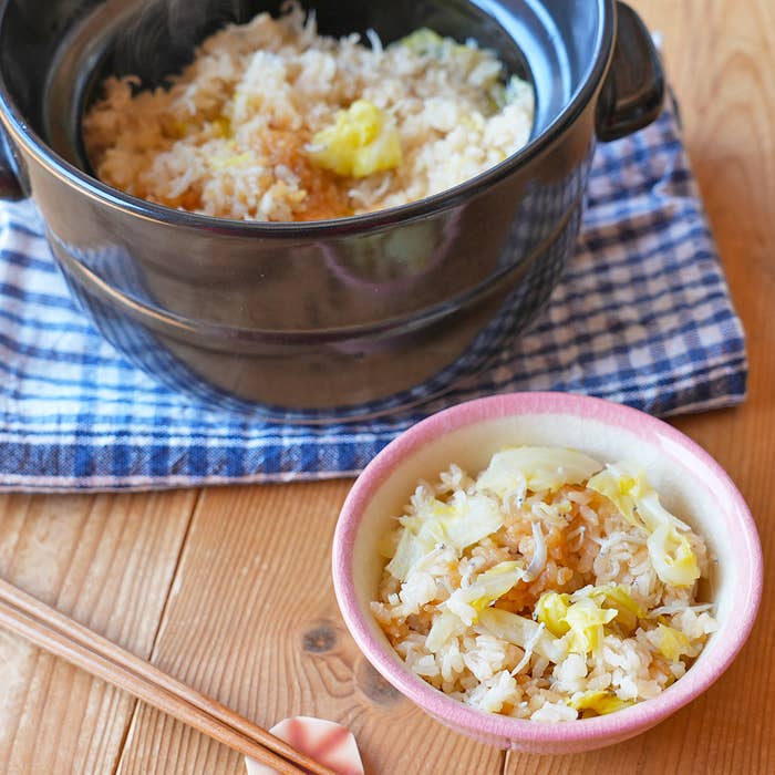 ご飯の上にキャベツ乗った丼とその一部が盛られた小さなお椀がテーブルクロスの上に置かれています。