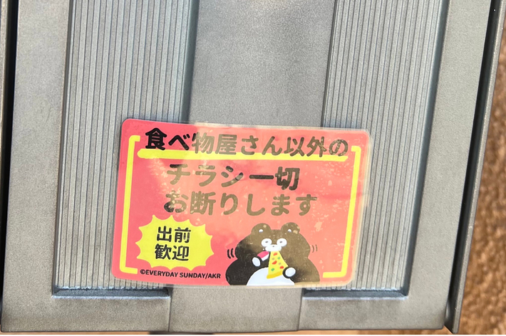 自動ペーパータオルディスペンサーに「チャージ中 お待ちください 完了」と書かれた赤い注意書きが表示されています。