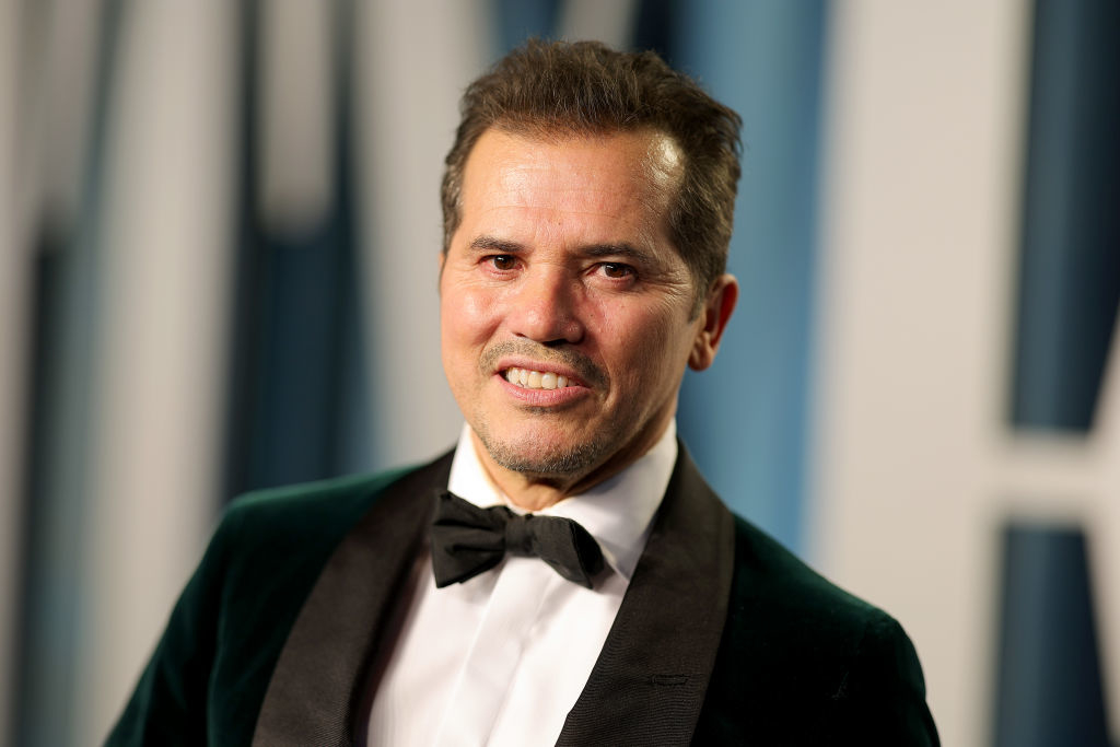 John Leguizamo at an event wearing a tuxedo with a bow tie. He is smiling