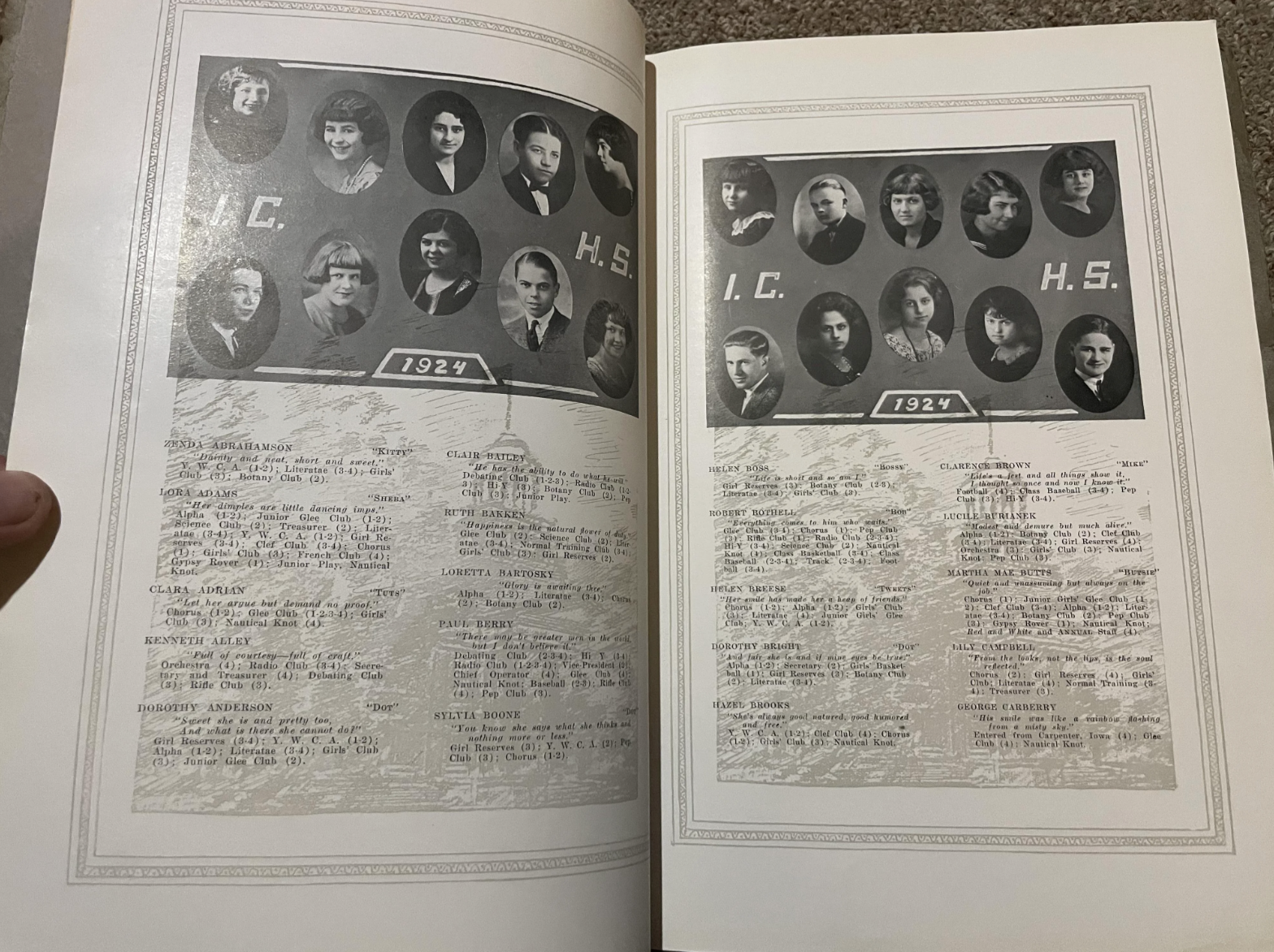 Open high school yearbook with photos of young men and women, signatures and messages, and typewritten names