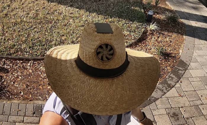 Person wearing a large straw hat with a vent on top, viewed from above