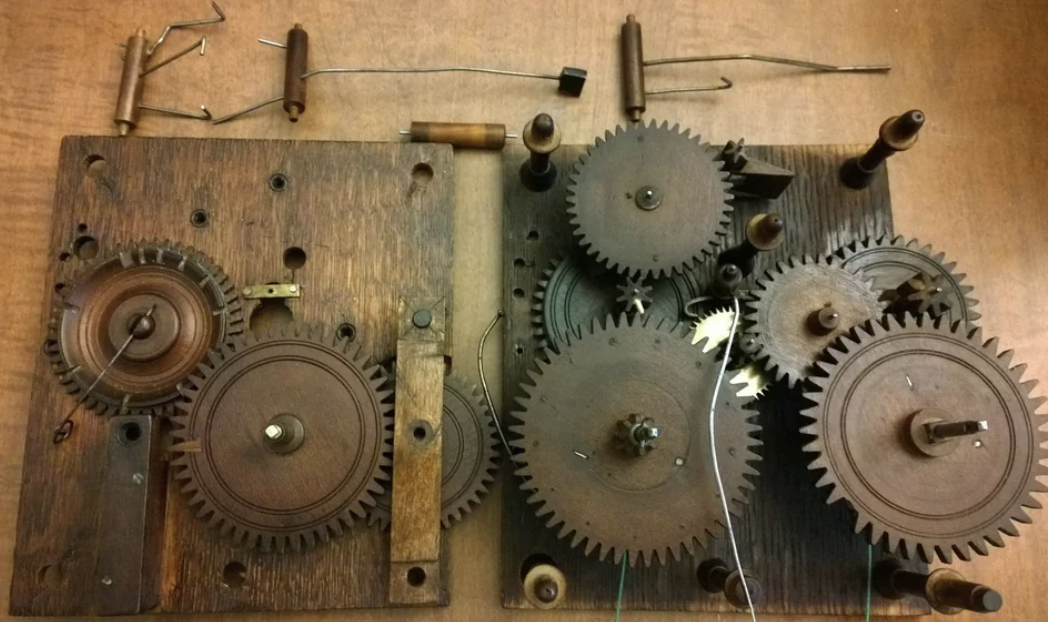 Vintage mechanical gears and parts displayed on a wooden surface