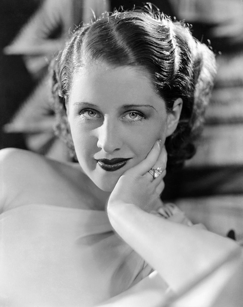 Classic portrait of Norma Shearer, hand on cheek, wearing a sleeveless top and ring