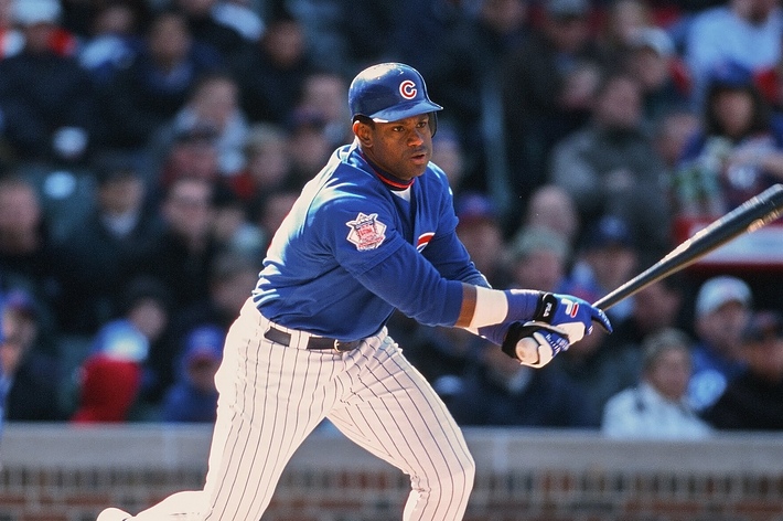 Baseball player in action during a game, wearing a Chicago Cubs uniform and swinging the bat