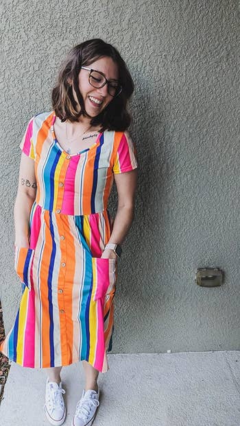 person in a striped knee-length dress with buttons paired with white sneakers
