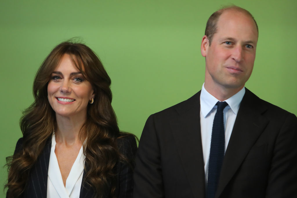 Kate and William standing side by side, both dressed in formal attire, with the person on the left in a blazer