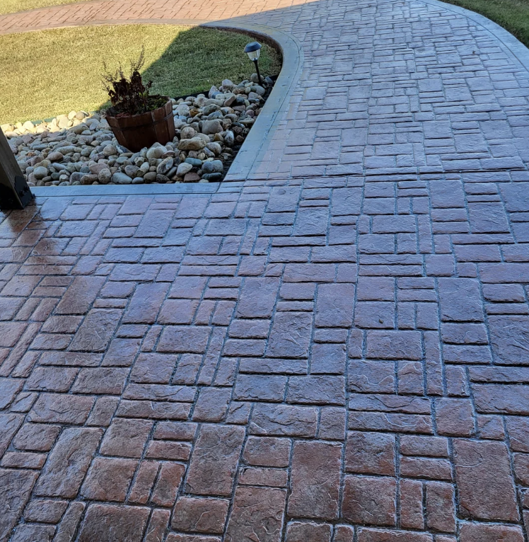 Stamped concrete pathway leading through the front yard of a house
