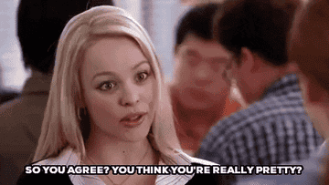 Scene from 'Mean Girls' with character Regina George speaking at a table