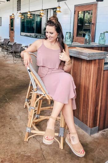 reviewer wearing the dress in light pink with sandals