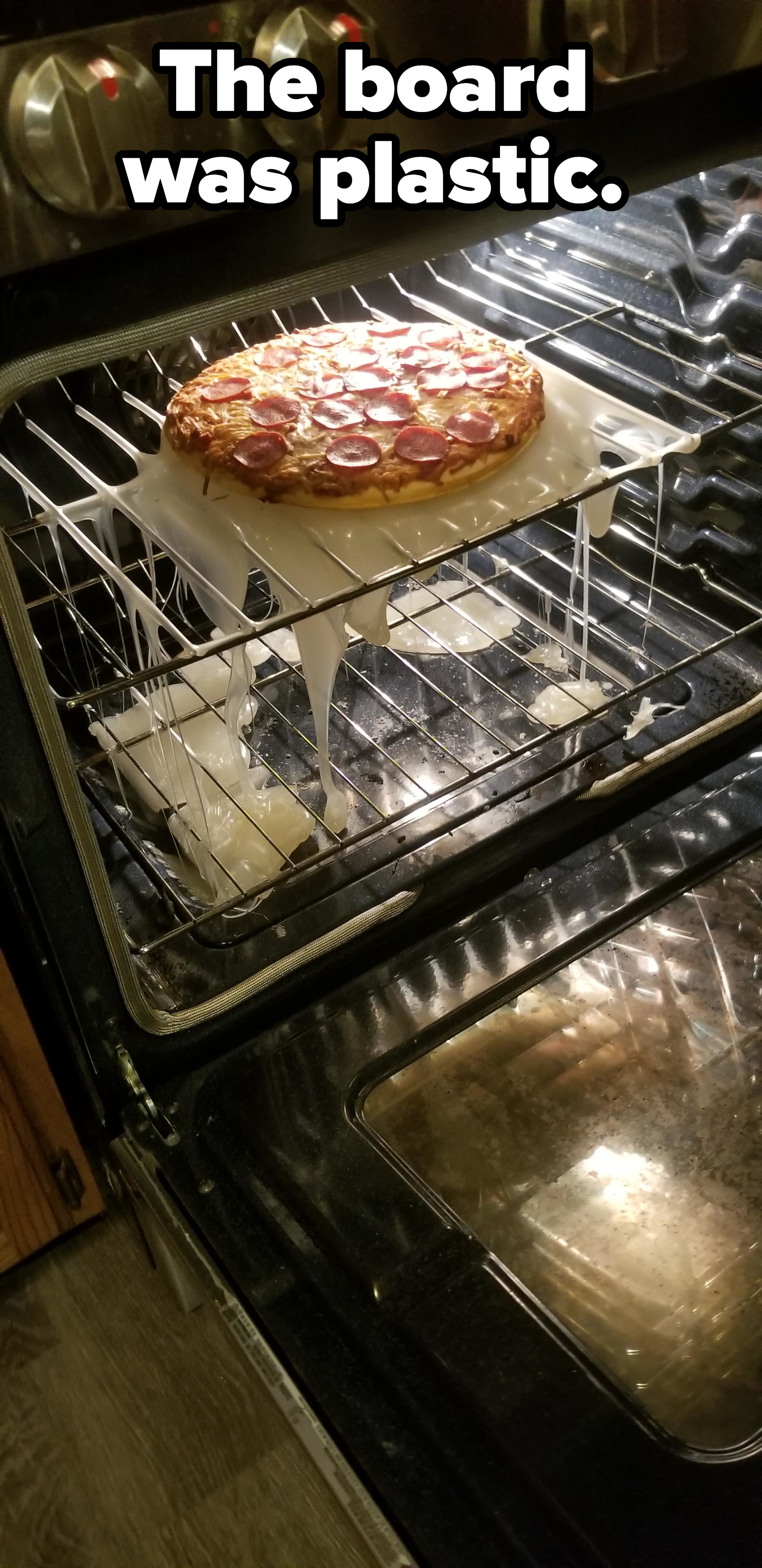 A pizza in an oven on a plastic tray that has melted through the oven rack