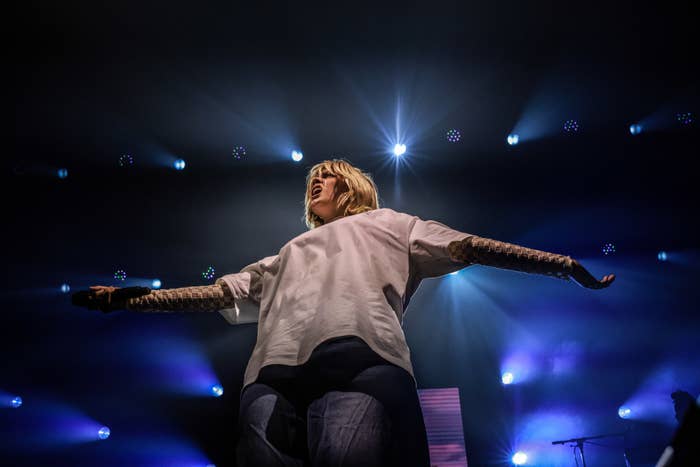 renee performing on stage with her arms stretched out