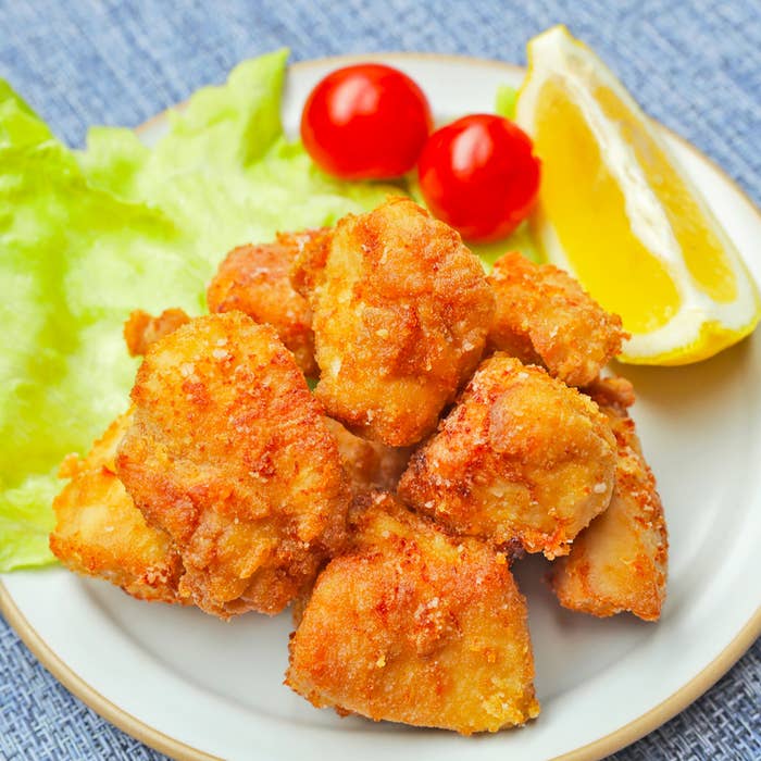 皿に盛られた唐揚げとレタス、トマト、レモンの写真です。