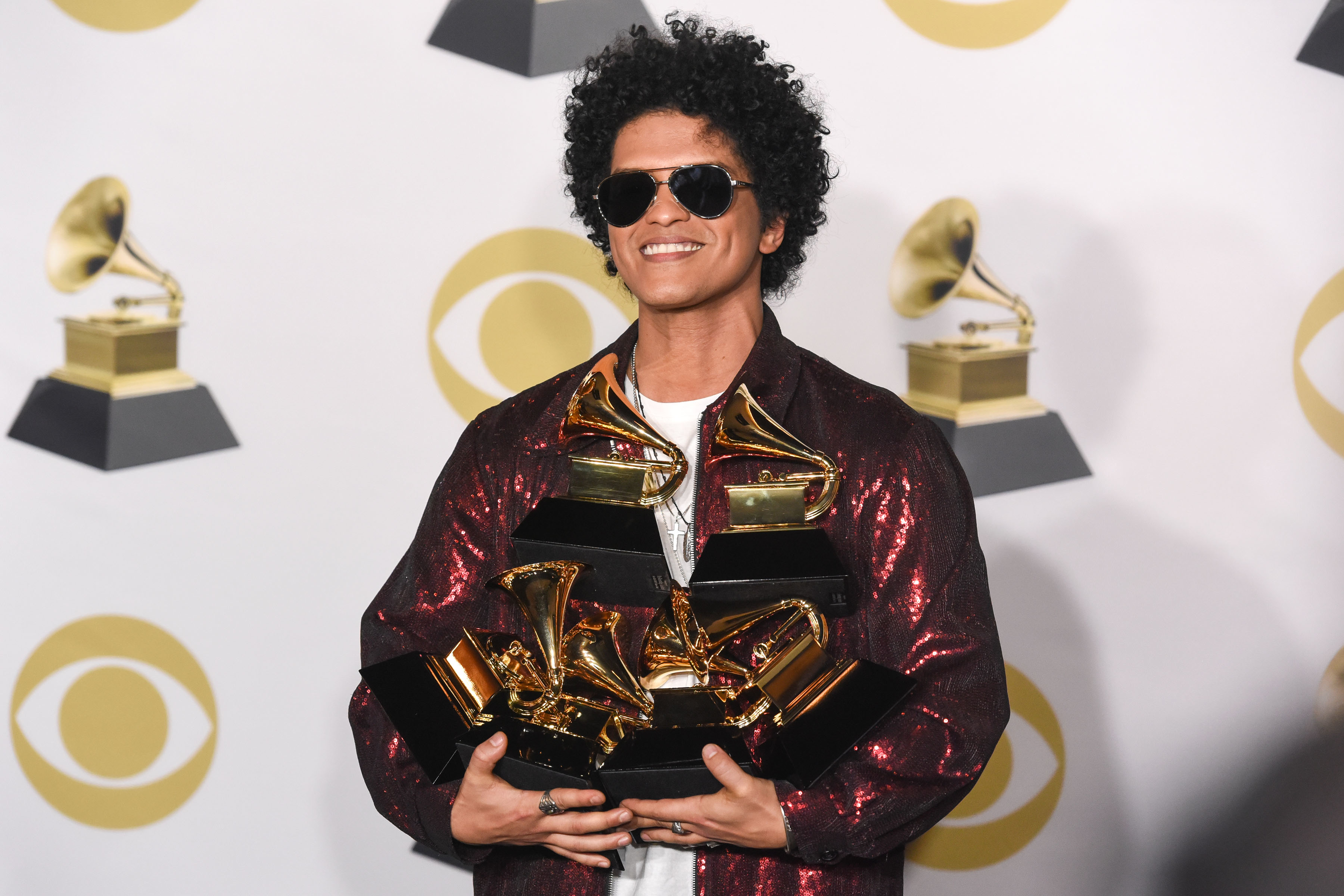 Bruno Mars holding his Grammy awards
