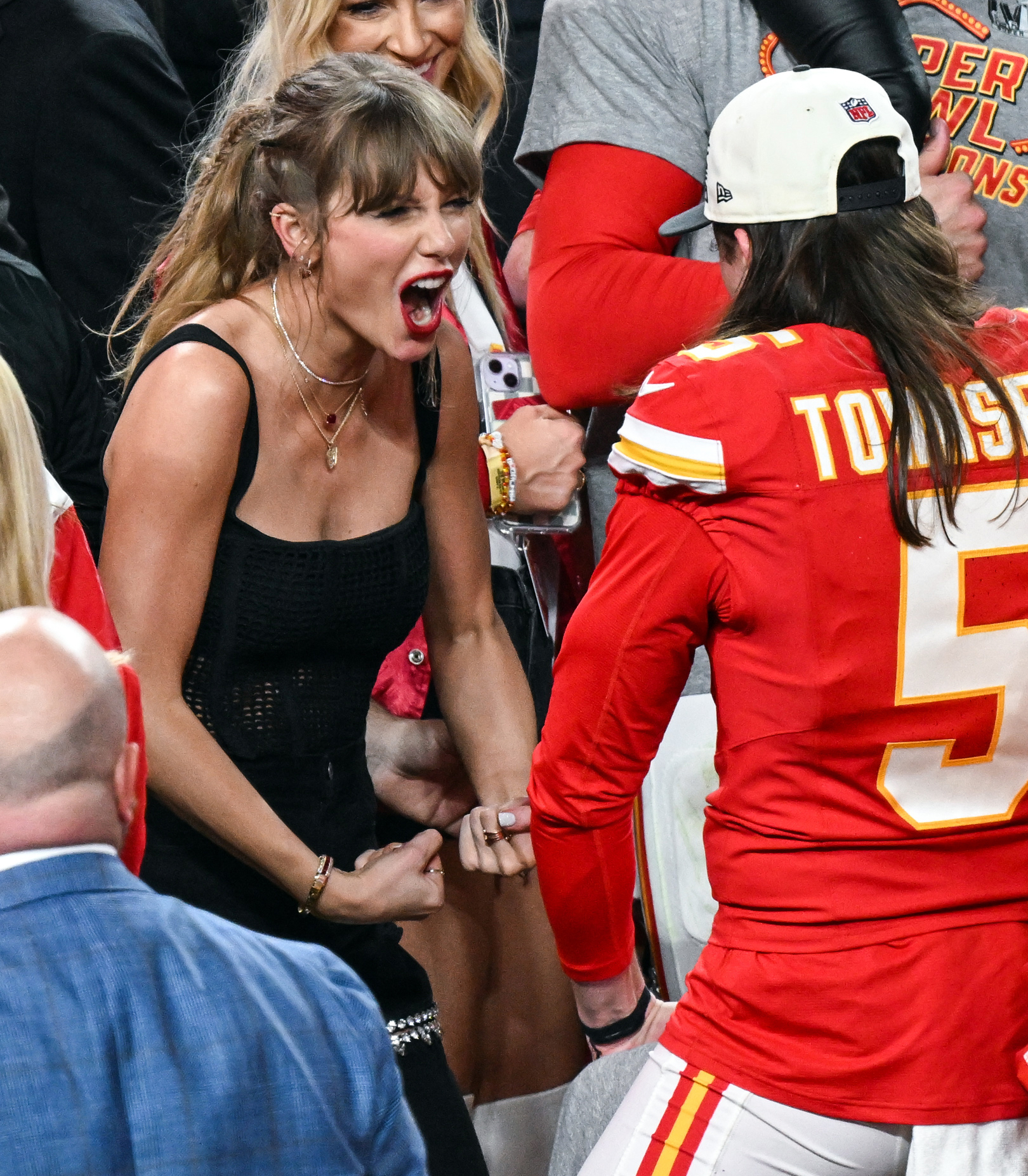 Taylor Swift smiling and flexing with the Kansas City Chiefs as they celebrated their Super Bowl victory