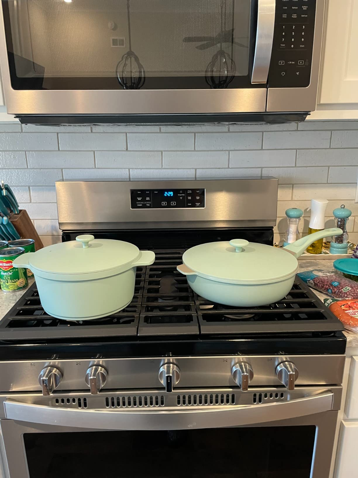 the pan and matching pot in sage green on a stove