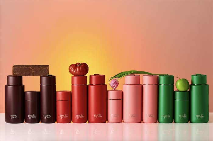 A collection of skincare products arranged in size order, resembling a gradient, with natural elements on them